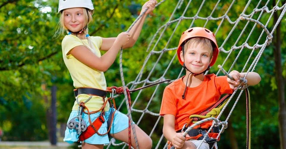 Smiling boy and girl playing when having fun doing activities outdoors. Happy childhood concept