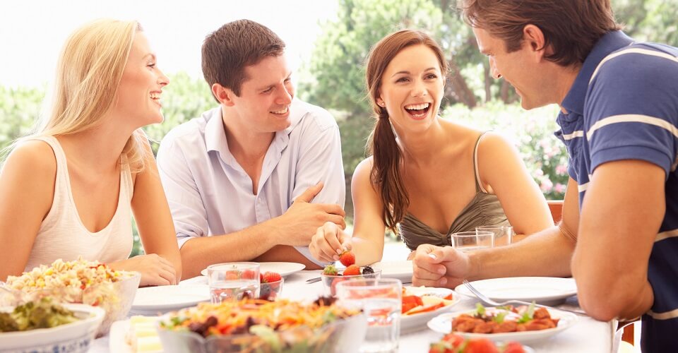 Two young couples eating outdoors