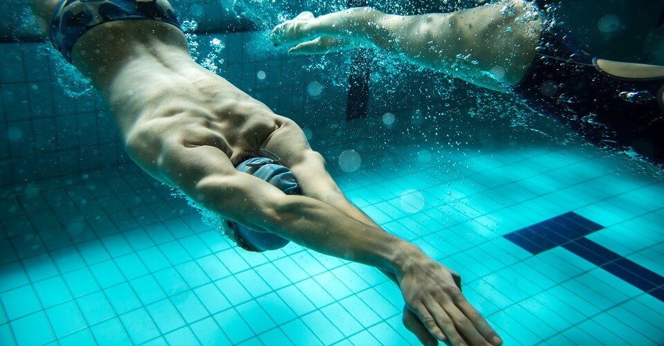 Two swimmers at the swimming pool.Underwater photo.